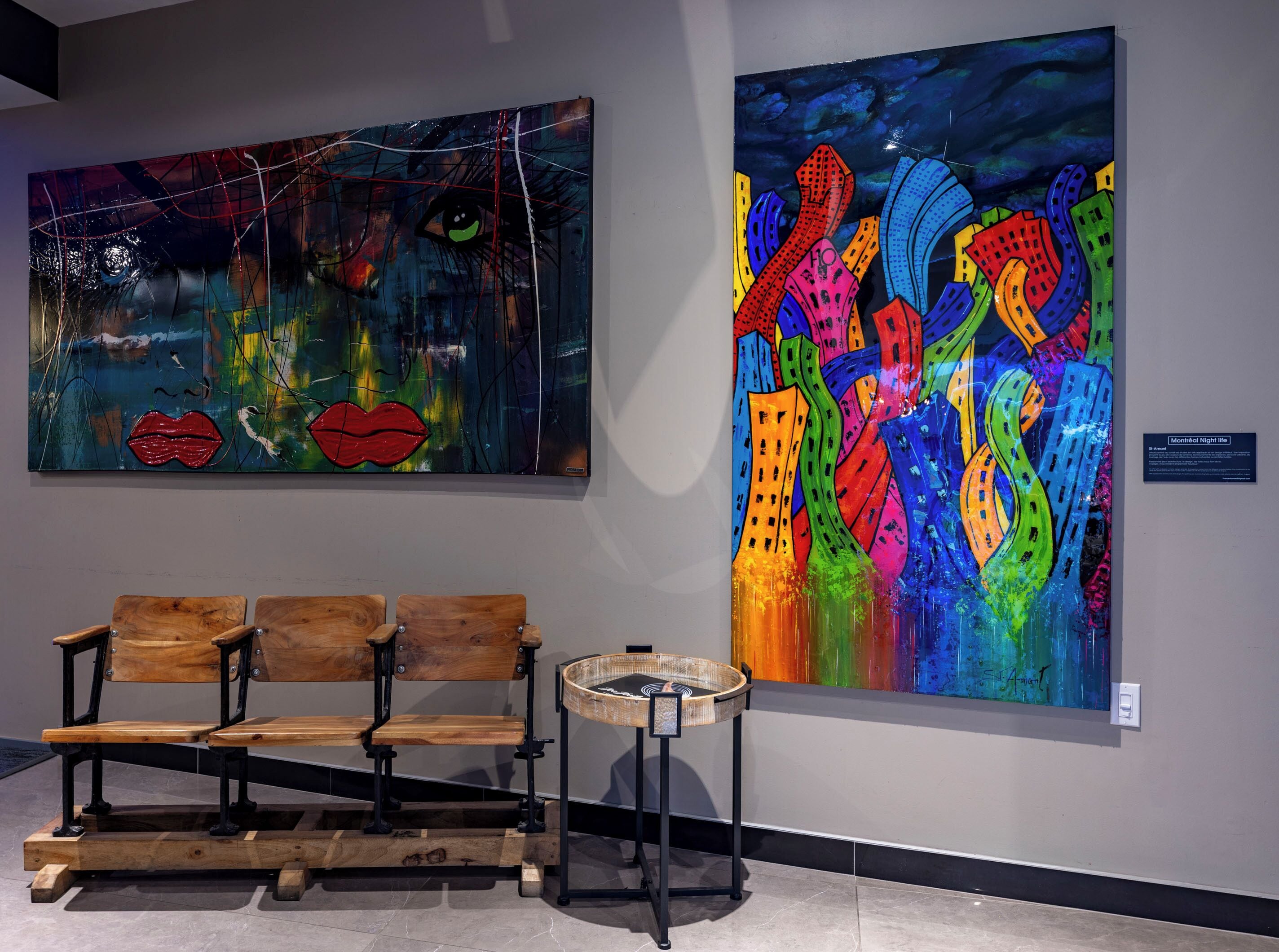 Two large abstract paintings on a wall, a wooden bench, and a small table with a basket.
