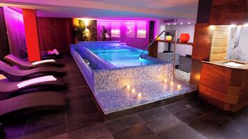 Relax by the pool surrounded by comfortable lounge chairs and a wooden bench.