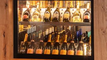 A wine display case with various bottles of Ruinart and Veuve Clicquot champagne.