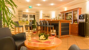 Eine Hotelhalle mit Rezeption, Bar und Sitzgelegenheiten.