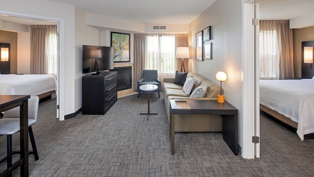 A hotel room with two beds, a desk, a sofa, a TV, and a lamp. - Residence Inn by Marriott Whitby (Whitby)