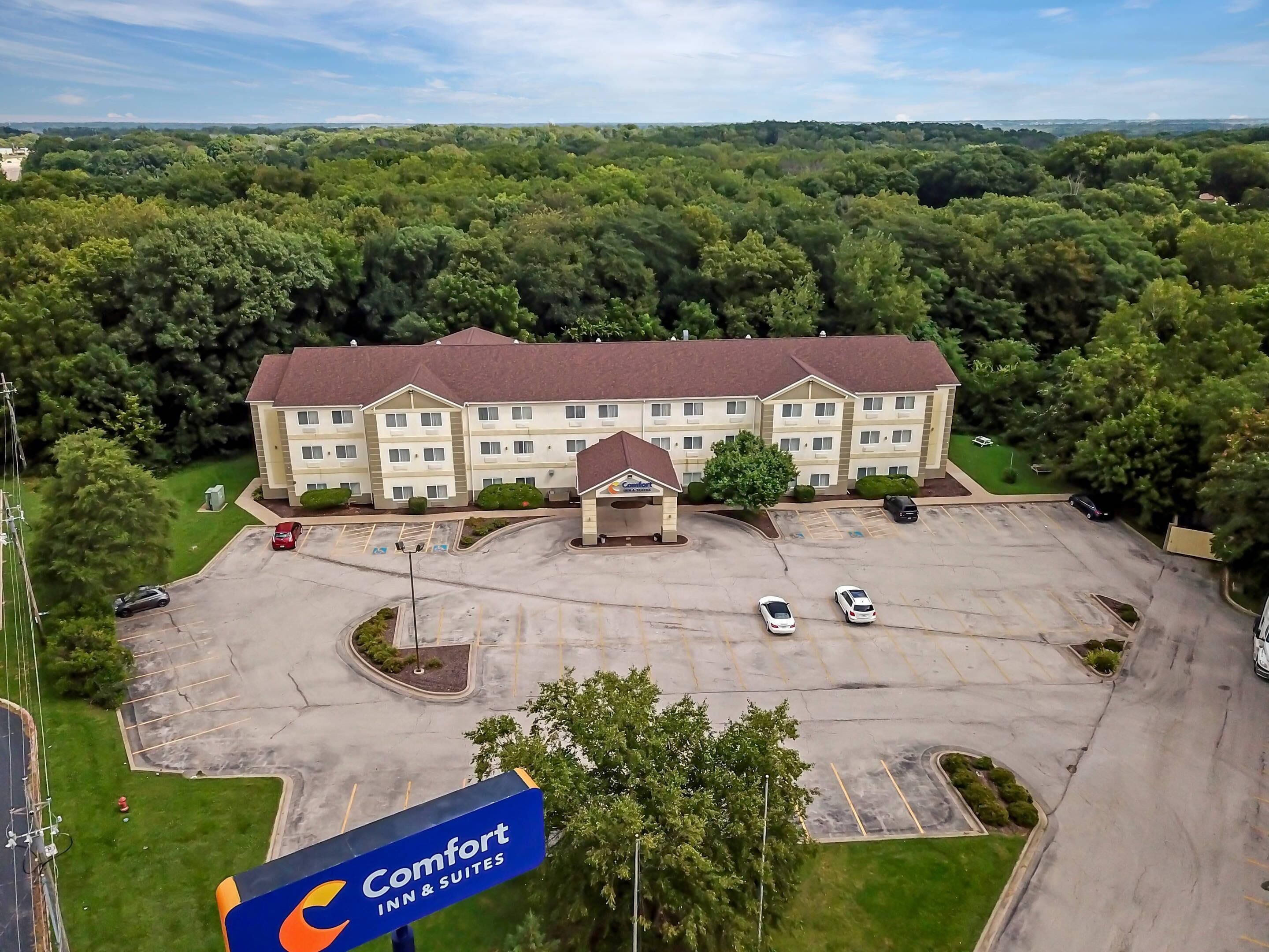 Un hôtel Comfort Inn & Suites doté d’un parking et entouré de verdure.