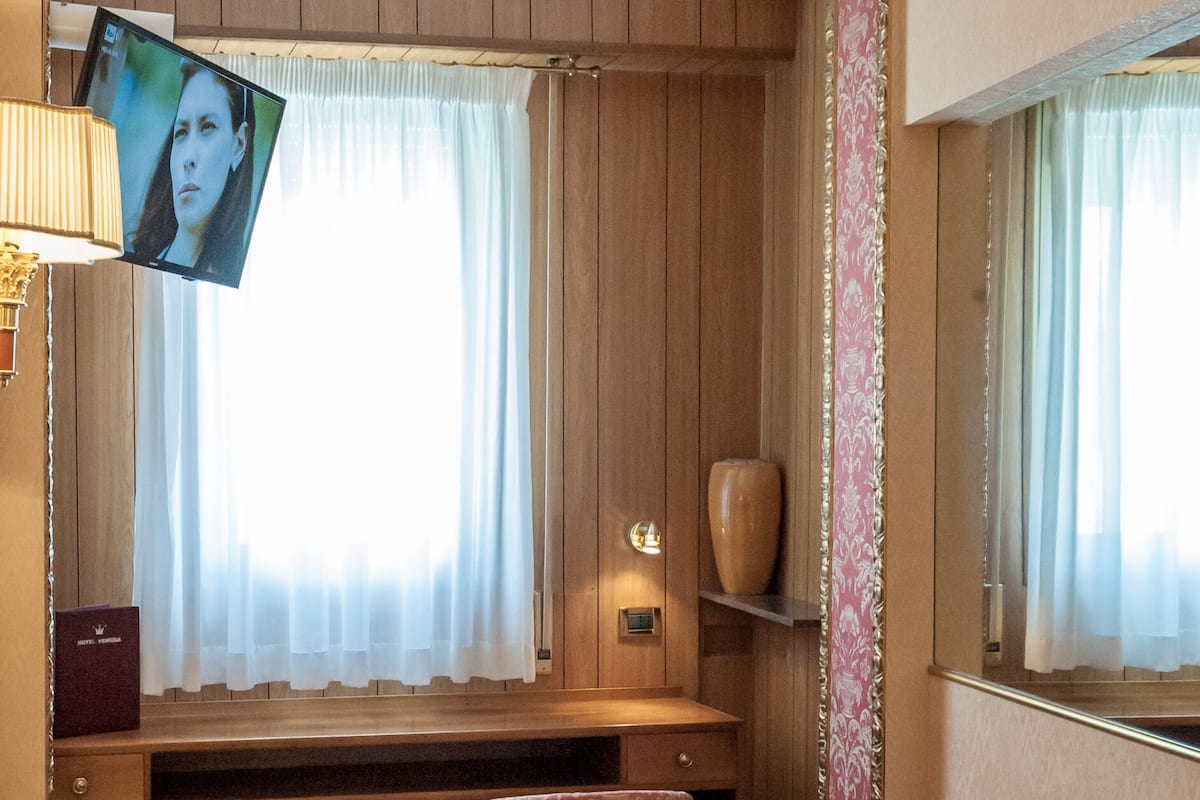Una habitación con cama, escritorio y televisor.