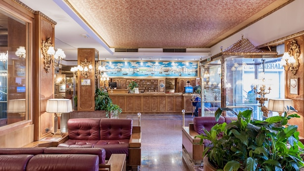A lobby with plush seating, a reception desk, and a decorative mural. - Hotel Venezia (Mestre)