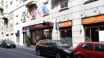 Un hotel llamado "Hotel Pavone" con un cartel que muestra varias banderas, incluida la bandera de la Unión Europea.