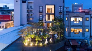 A rooftop garden with seating areas and a view of surrounding buildings.