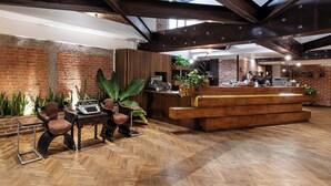 A reception area with a wooden desk, chairs, and a plant.