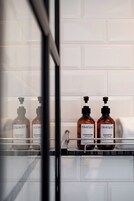 A bathroom shelf with two bottles of BlueSpa conditioner and shampoo, and one bottle of BlueSpa shower gel.