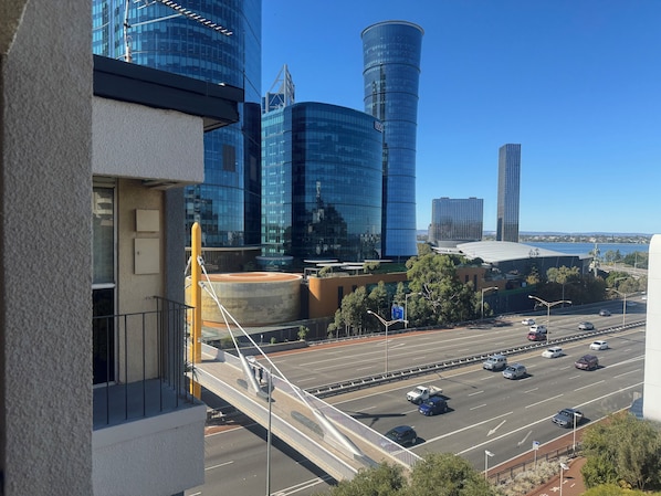 A modern urban landscape with high-rise buildings, a bridge, and a highway.