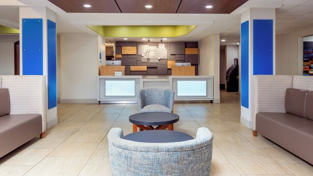 A modern lobby with a reception desk, seating area, and a wooden ceiling with recessed lighting. - Holiday Inn Express Jacksonville - Blount Island by IHG (Jacksonville)