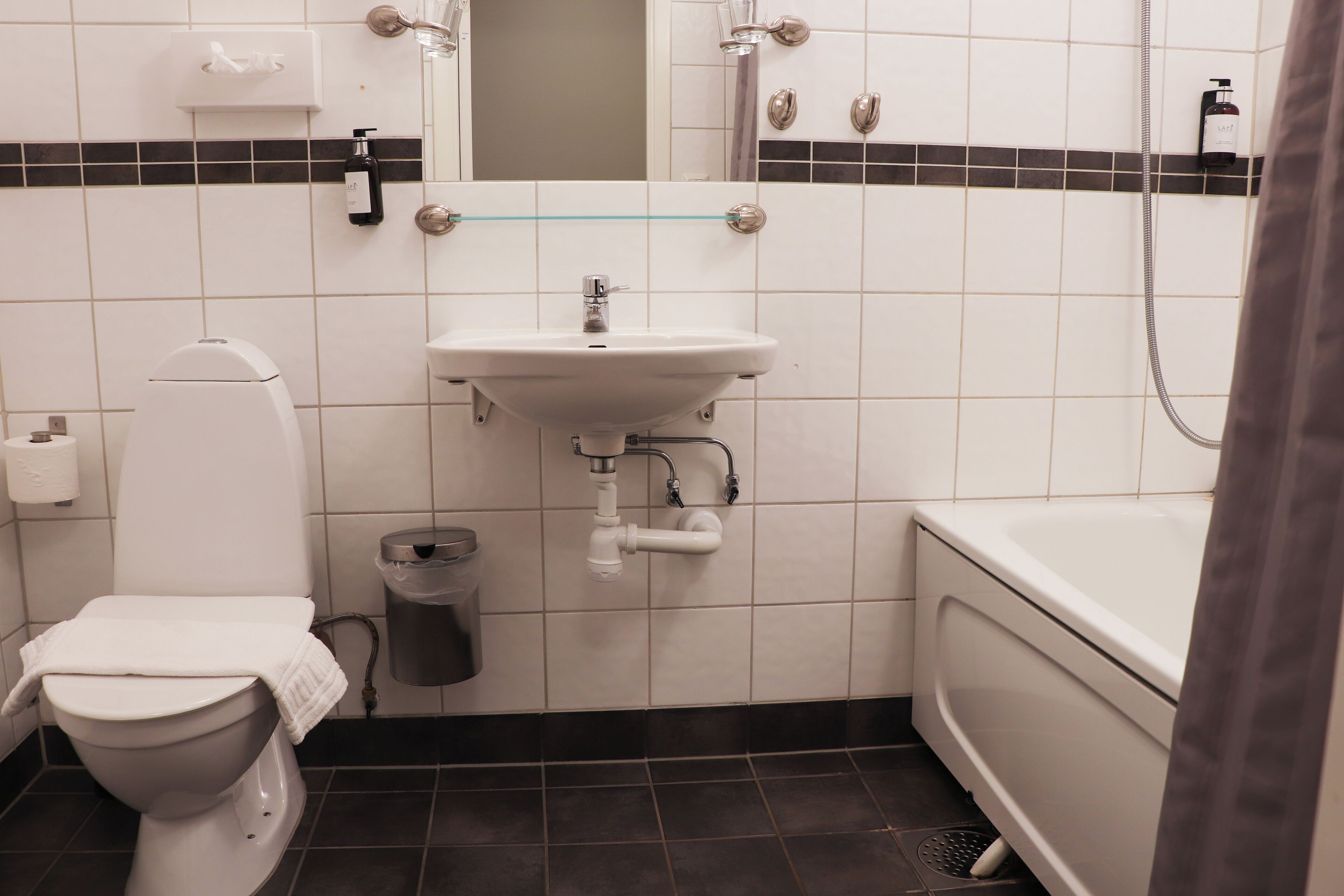 Un baño con inodoro, lavamanos y bañera.