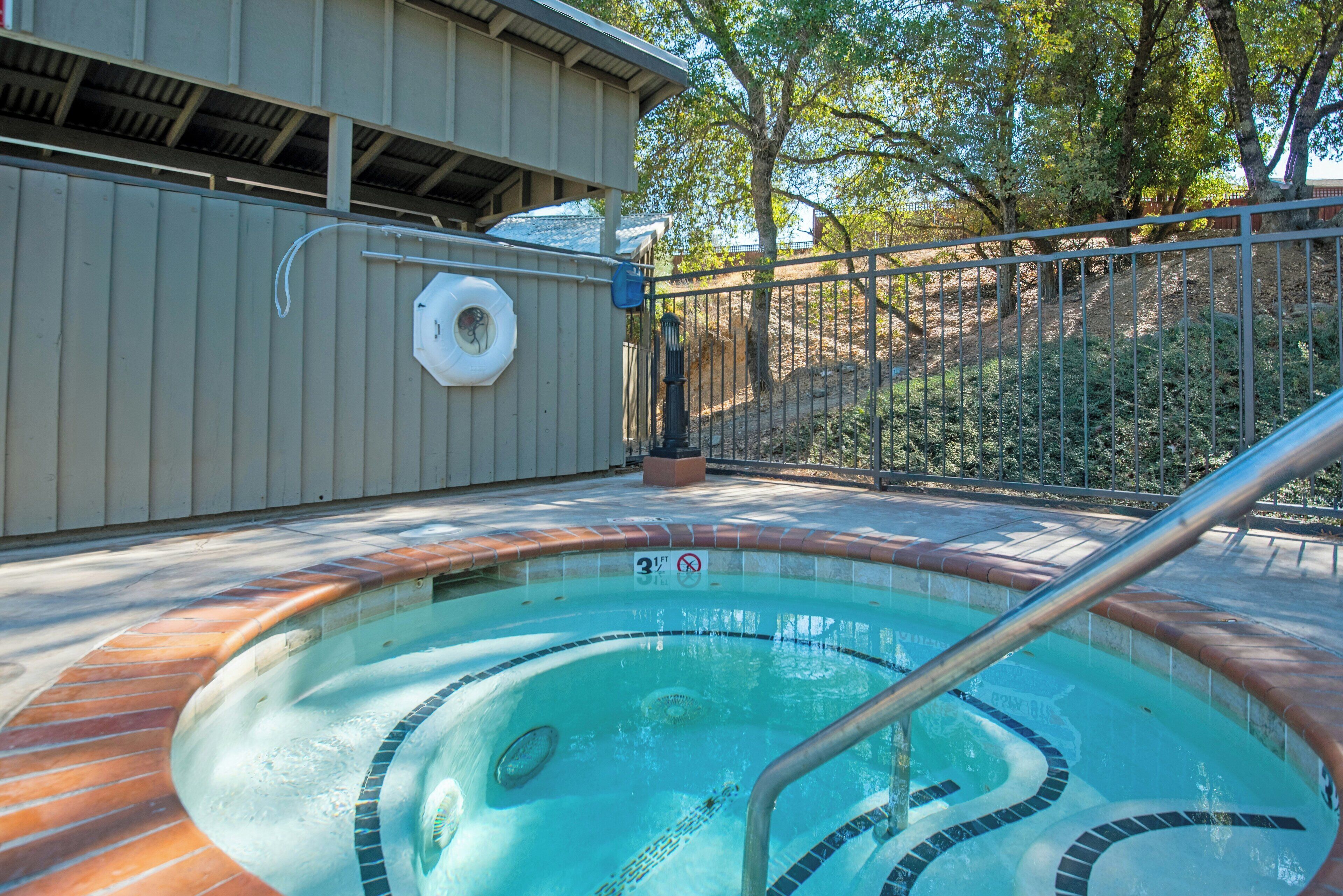 A swimming pool with a tiled edge, a metal handrail, and a no diving sign.