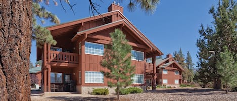 A large, two-story lodge with a prominent wooden exterior, large windows, and a covered porch area.