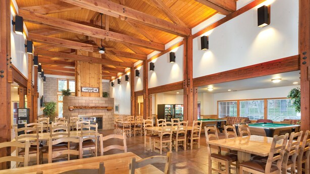 A spacious indoor area with wooden tables and chairs, a pool table, and a fireplace. - WorldMark Big Bear Lake (Big Bear Lake)