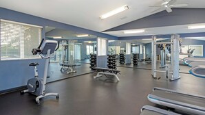 A gym with exercise equipment, mirrors, and a ceiling fan. - Worldmark Birch Bay (Blaine)