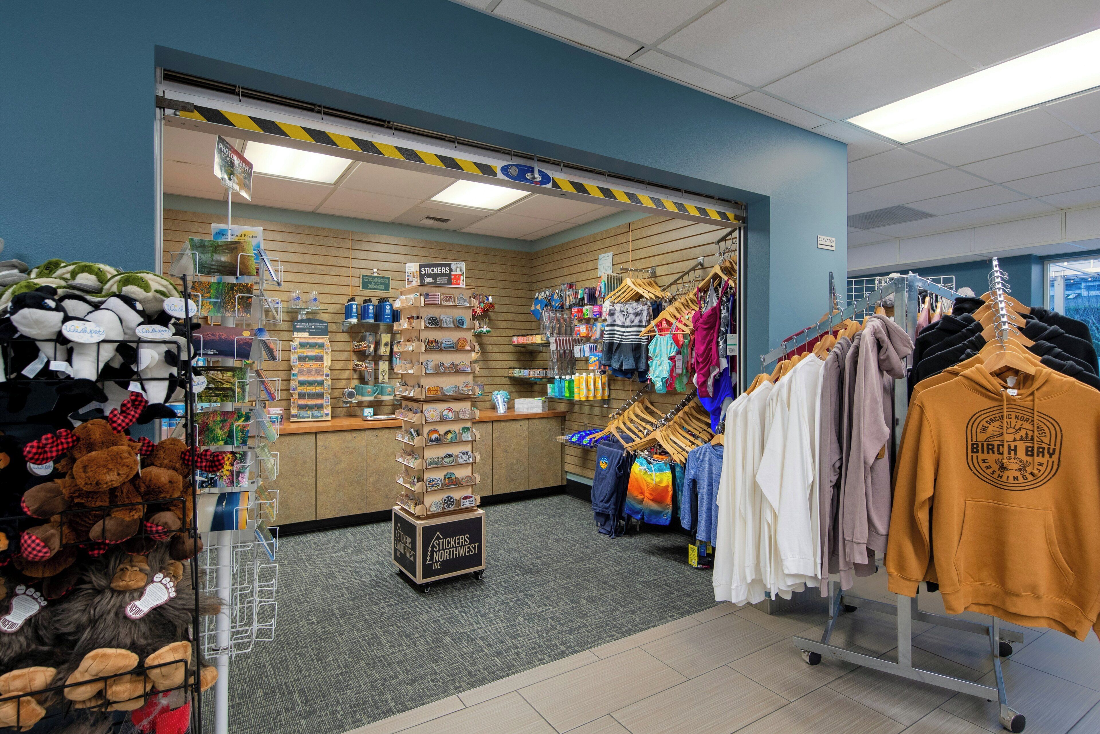 Interior de botiga amb prestatges de roba, una presentació d'ossos de peluix i una barra amb diversos productes.