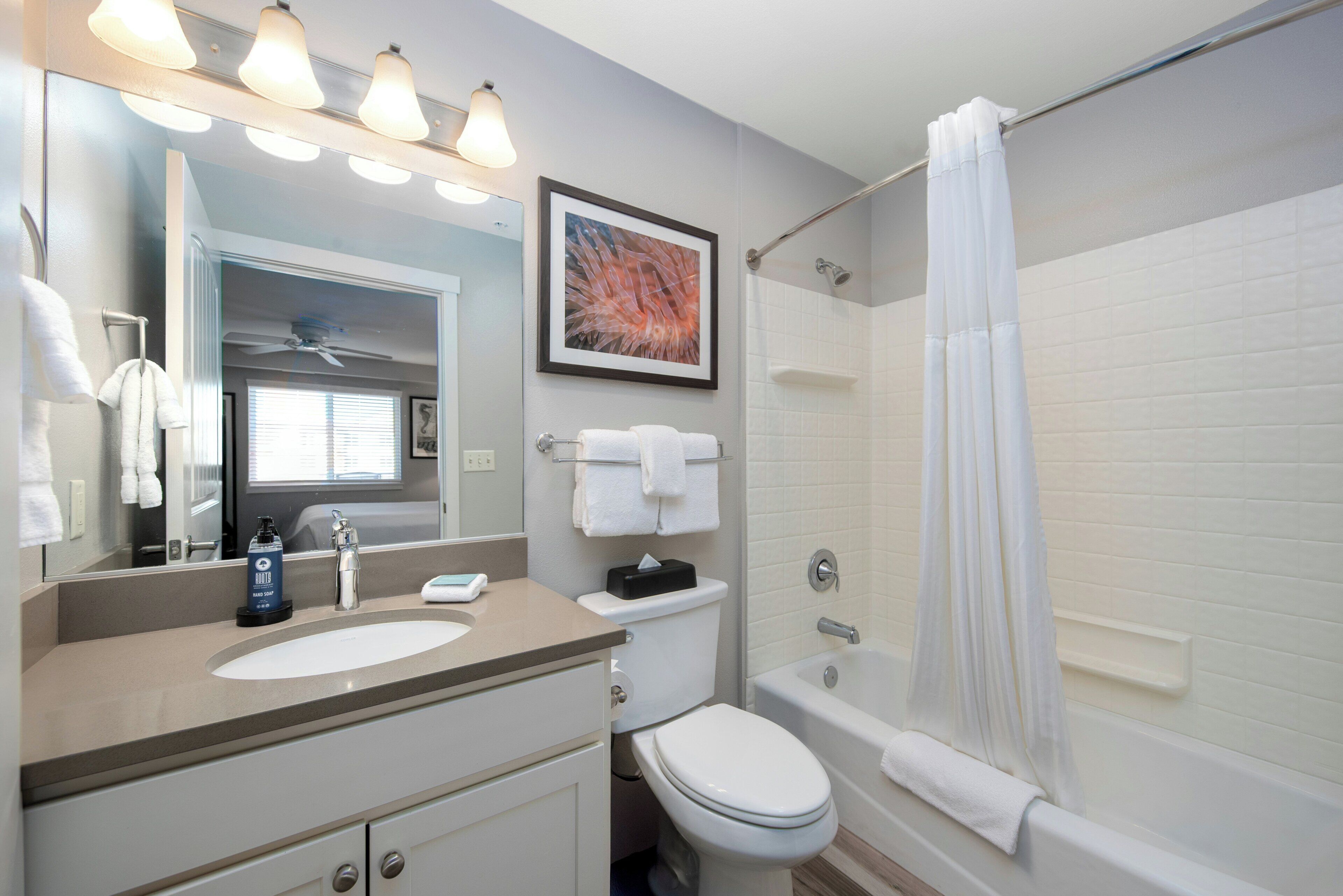 A bathroom with a sink, toilet, bathtub, and shower curtain.
