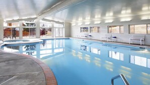 An indoor swimming pool with clear blue water, surrounded by white walls and large windows. - WorldMark Bear Lake (Garden City)
