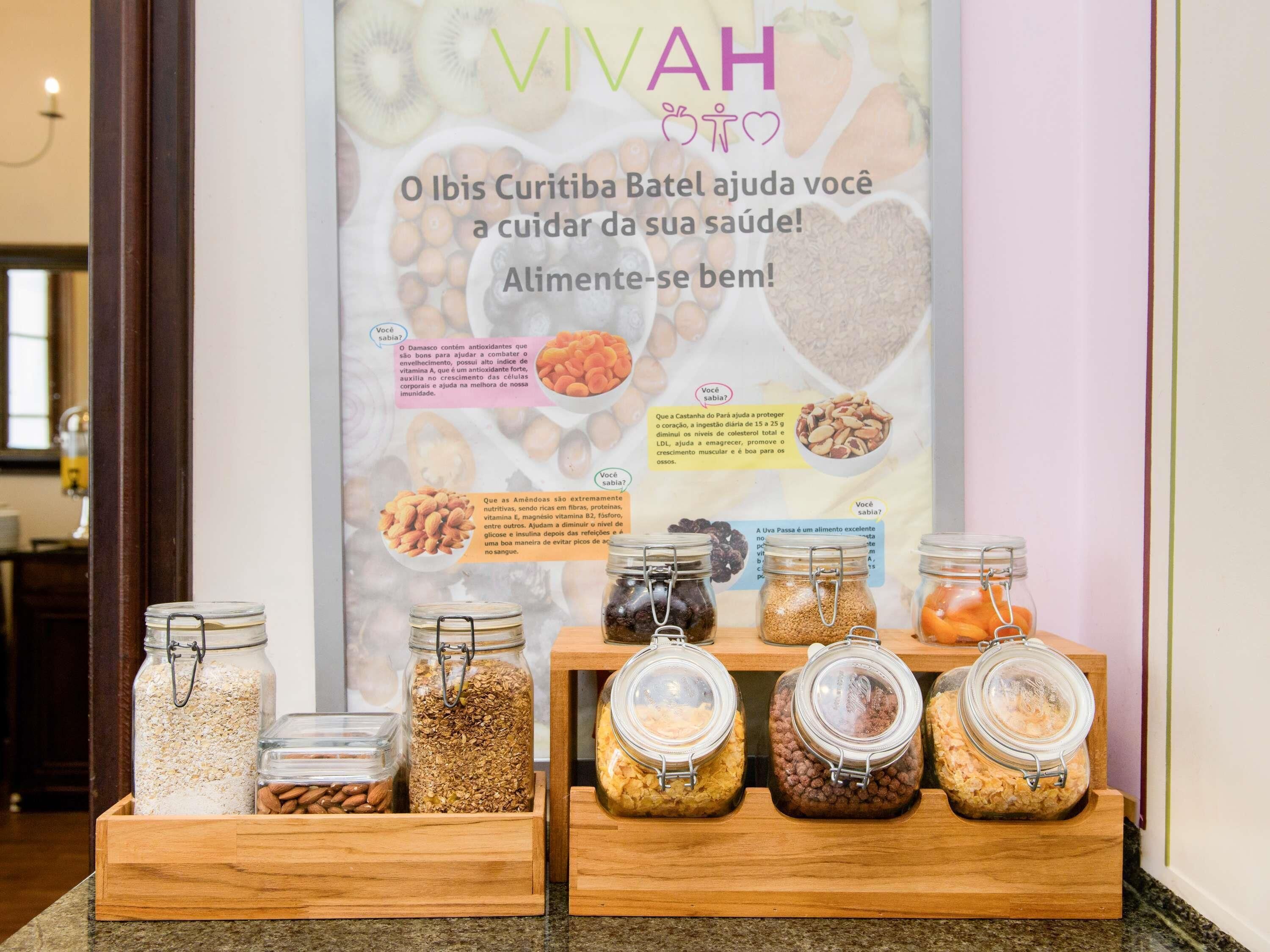 A health-focused display with jars of nuts and grains, a poster with health tips, and a wooden counter.