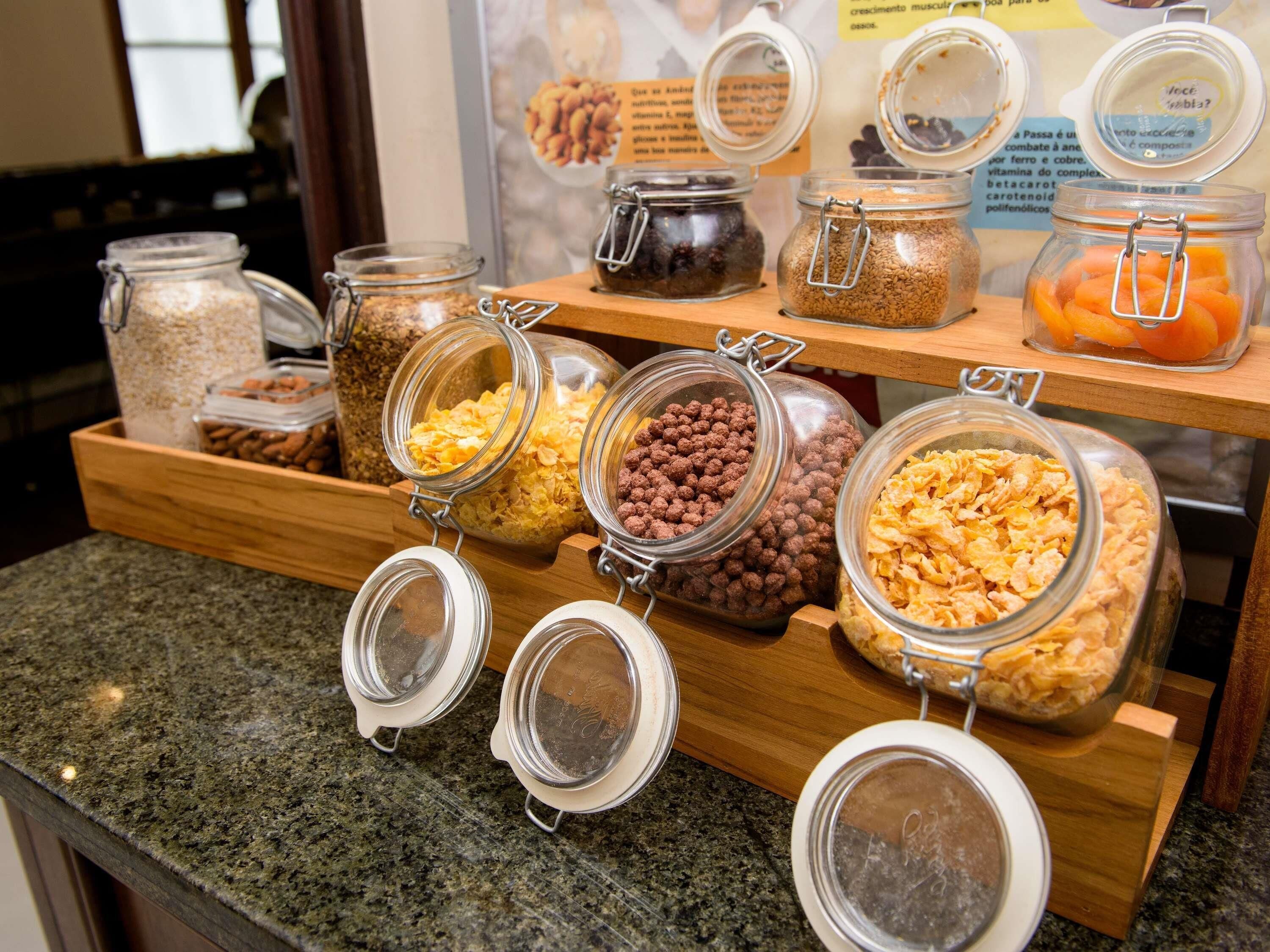 Una barra de desayuno con diversos alimentos en recipientes de vidrio.