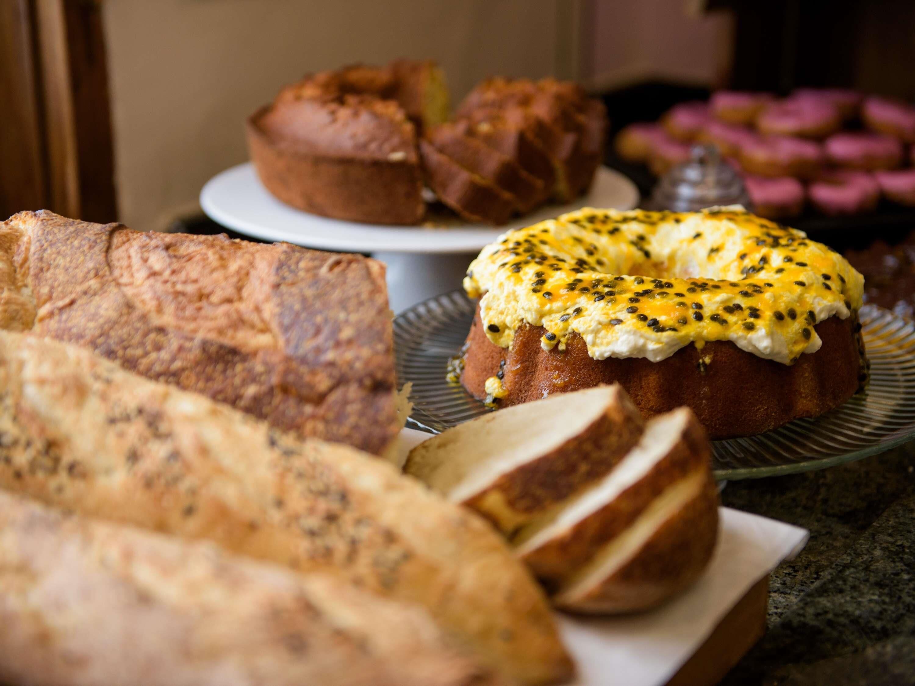 A variety of baked goods including bread, muffins, and a cake with a topping of seeds.
