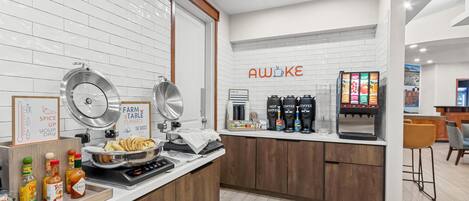 Una zona de cocina con estación de café, un letrero que dice 'AWOKE' y un letrero de 'FARM TO TABLE Classics'.