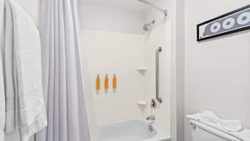 A bathroom with a shower, toilet, and a towel rack.