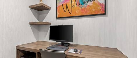 Un escritorio moderno de oficina con computadora, teclado, ratón e impresora.