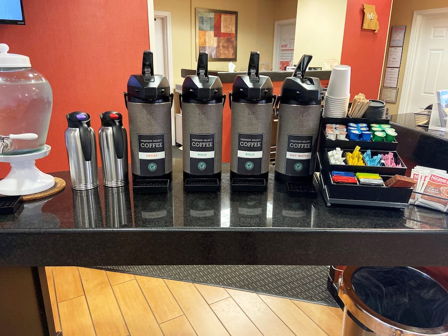 A coffee station with multiple coffee dispensers labeled 'Premium Select Coffee' in different flavors.