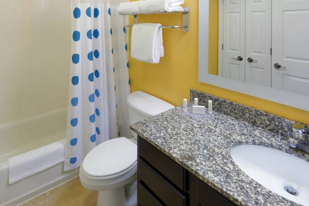 Een badkamer met bad, toilet en wastafel.