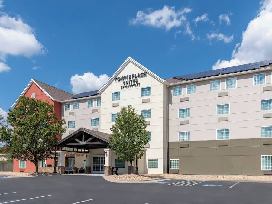 Un hotel con un cartello ben visibile con la scritta 'TOWNEPLACE SUITES BY MARRIOTT' e un parcheggio dotato di posti auto riservati ai disabili.