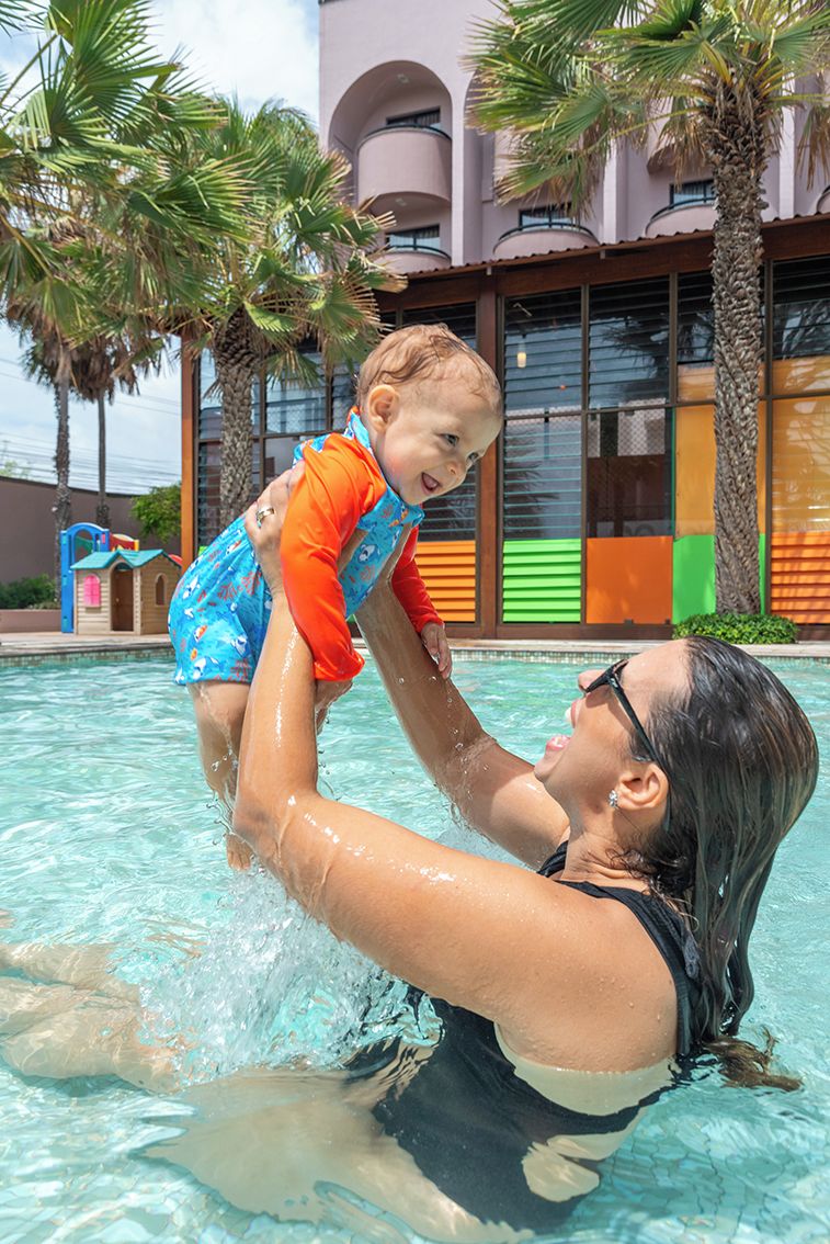Una piscina con una persona sosteniendo a un niño.