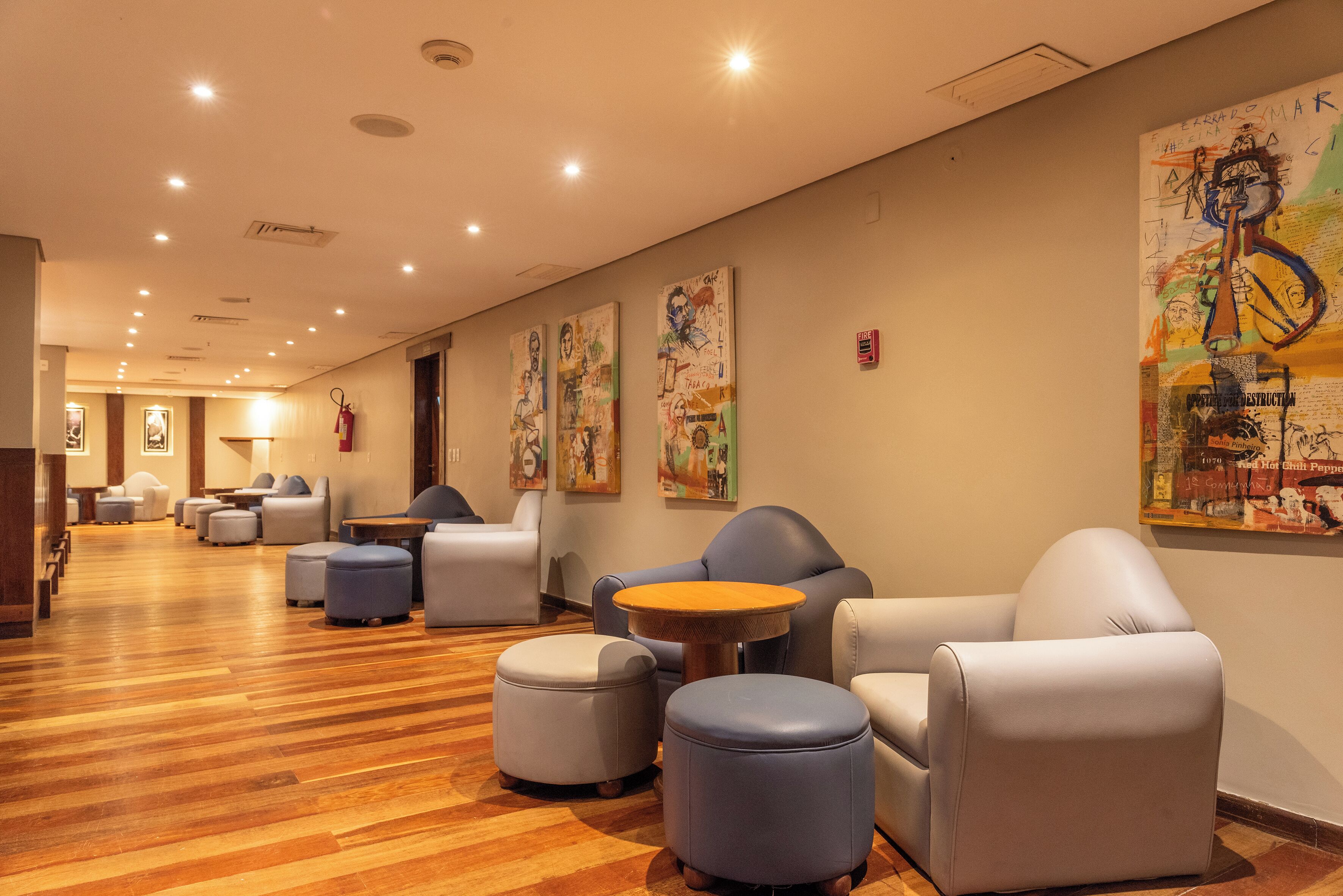 A hotel lobby with seating areas, wooden flooring, and artwork on the walls.
