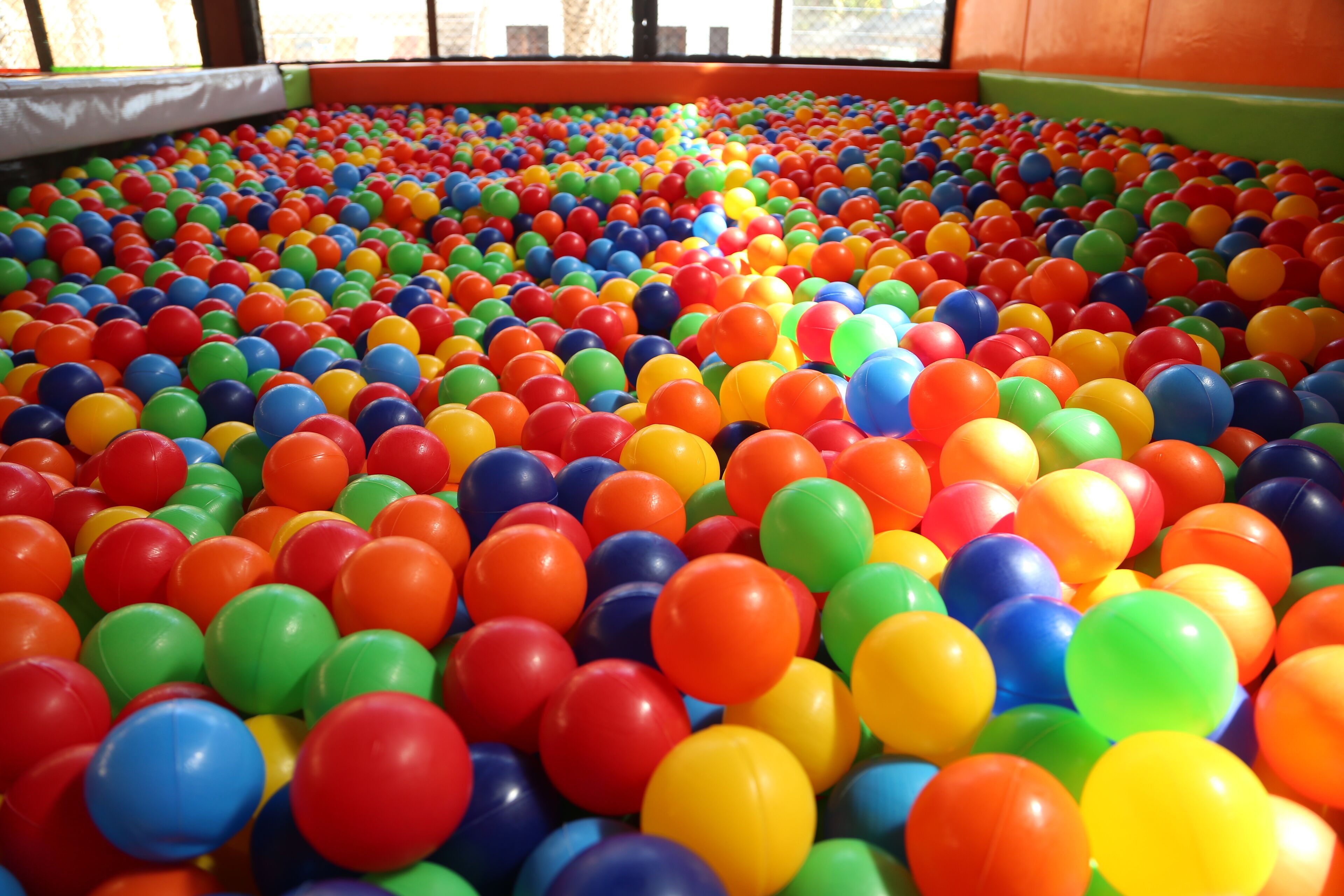 Un grand espace de jeux intérieur rempli de balles en plastique de toutes les couleurs.