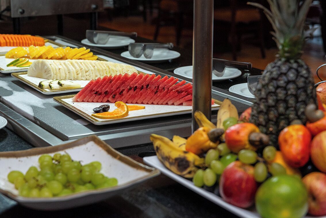 Un buffet con diverse varietà di frutta e verdura disposte su piatti.