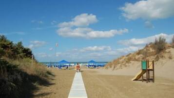 Aan een privéstrand, ligstoelen, parasols
