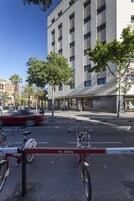 Un edificio moderno con fachada plana, varias ventanas y escaparate con un letrero.