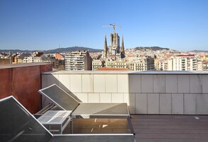 A rooftop terrace with a view of a cityscape, including a prominent cathedral.