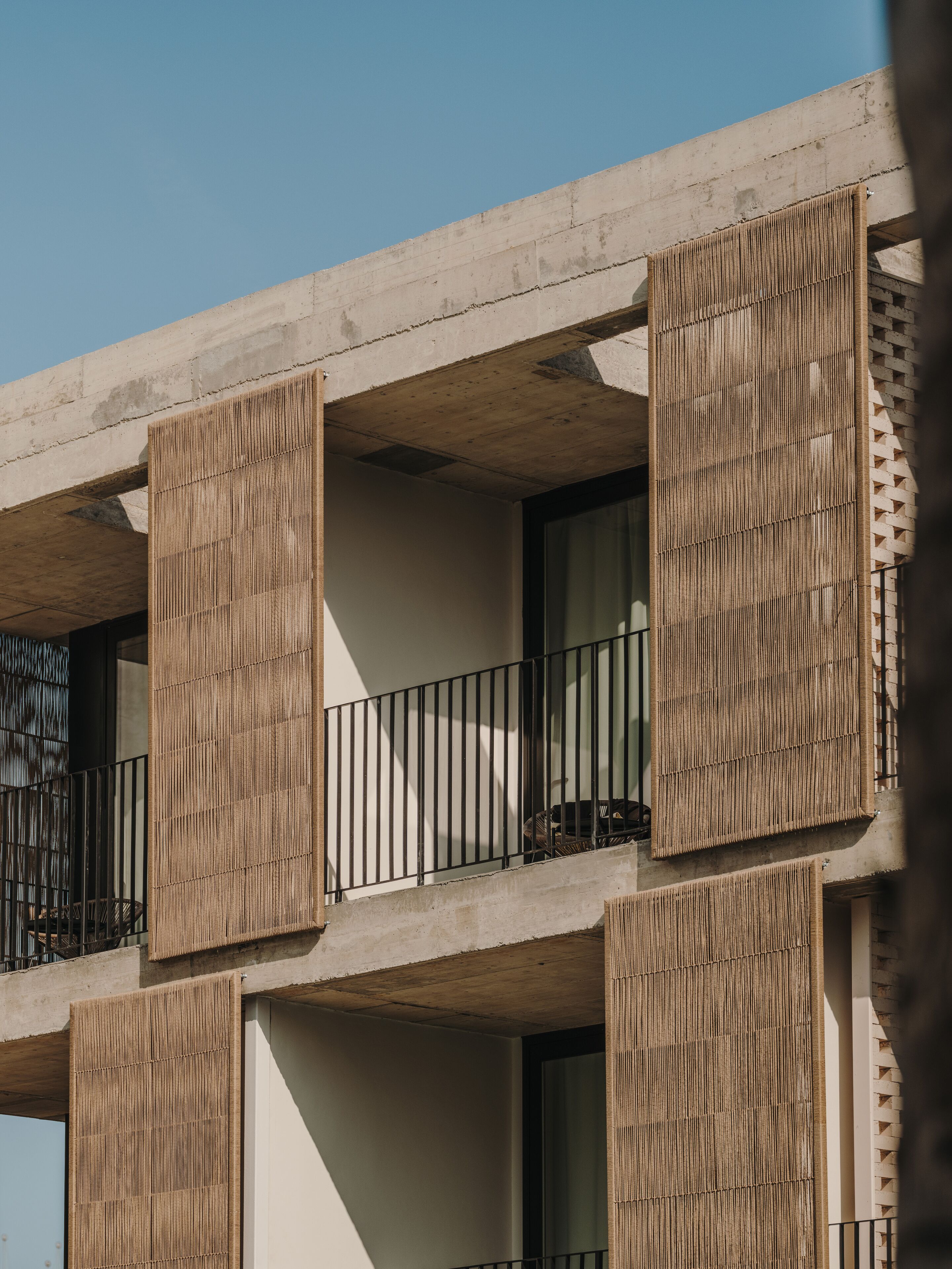 A modern building with concrete balconies and vertical wooden slats.