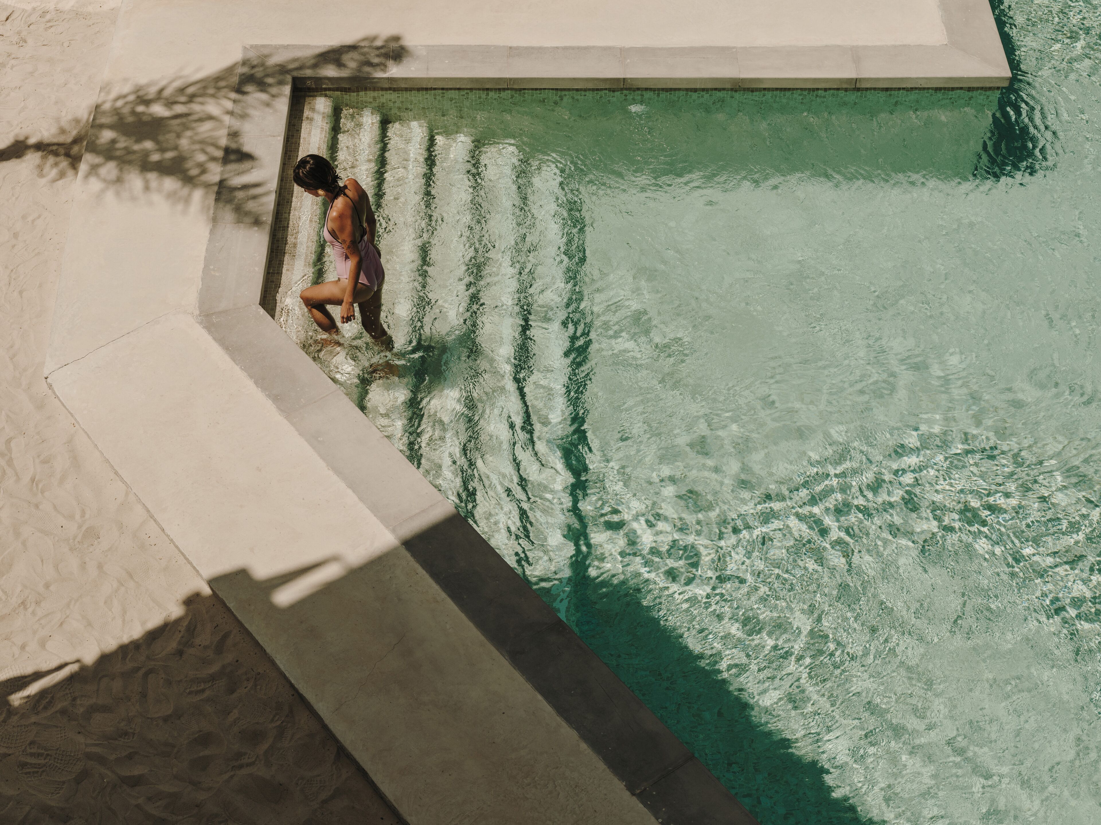 Una persona de pie al borde de una piscina.
