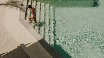 Una persona de pie al borde de una piscina.