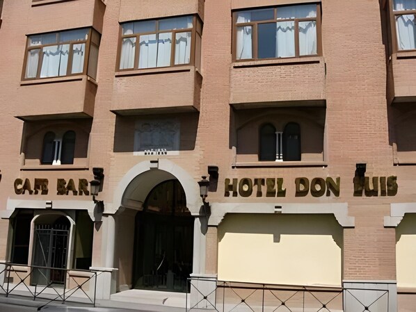 Un edificio con un bar-cafetería y un hotel llamado 'HOTEL DON LUIS' en la planta baja.