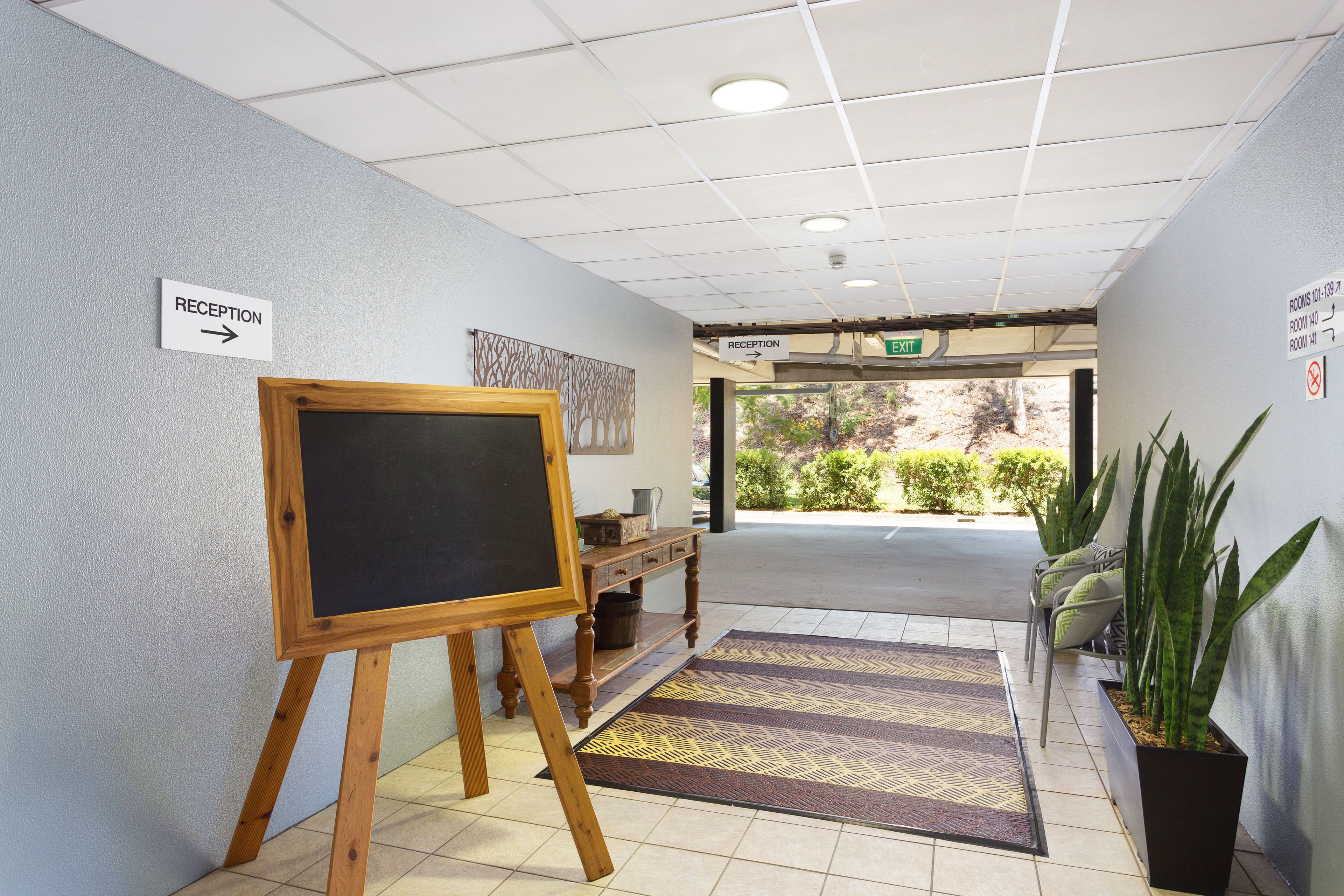 A reception area with a chalkboard, a reception sign, and an exit sign.