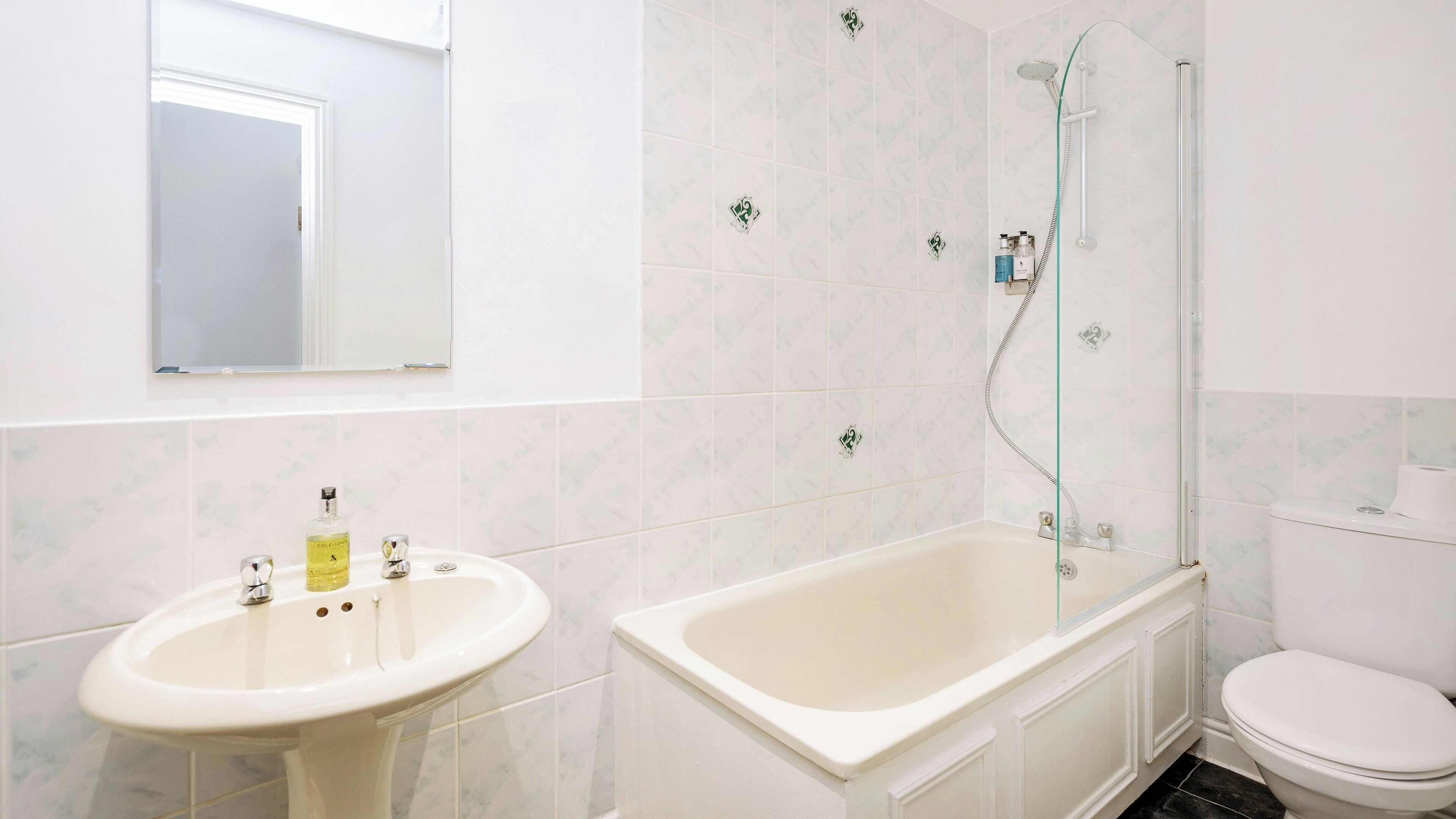 Un baño con lavamanos, bañera y retrete.