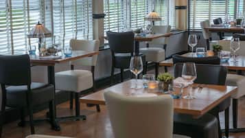 Un restaurante con mesas dispuestas para comer, con una decoración moderna que incluye mesas y sillas de madera.