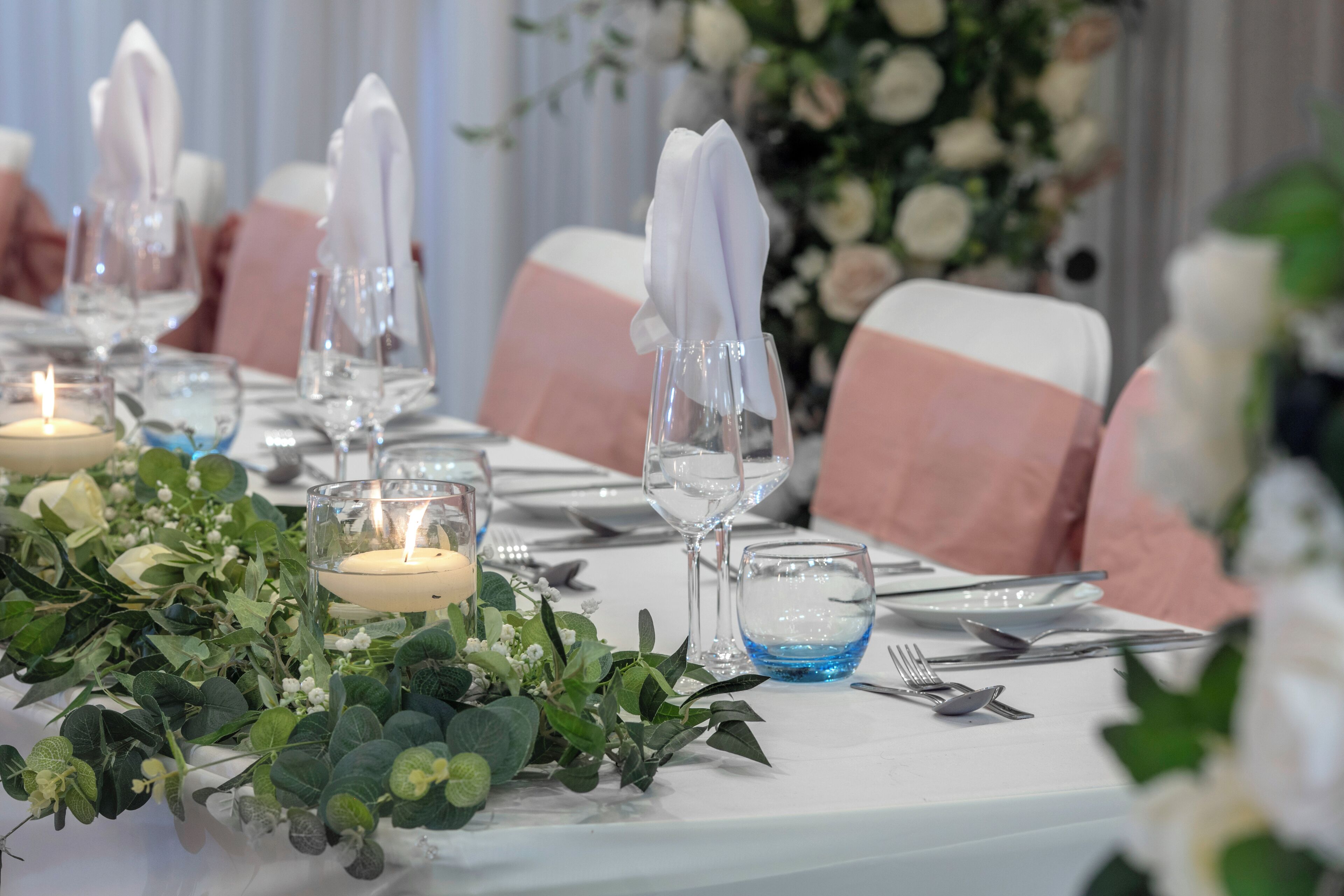 Una mesa dispuesta para un evento formal, con velas, copas y servilletas dobladas con esmero.