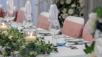 A table set for a formal event with candles, glassware, and neatly folded napkins.
