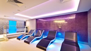 A modern spa room with four reclining chairs, a blue screen, and a purple textured wall. - Best Western Premier Suites Hotel & Spa Liverpool-Knowsley (Liverpool)