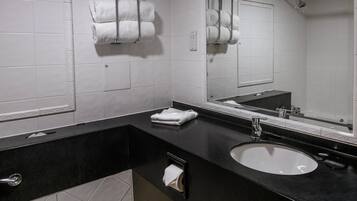 Ein modernes Badezimmer mit schwarzem Waschtisch, weißem Waschbecken und zwei Handtuchhaltern mit weißen Handtüchern.