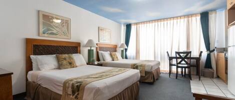Una camera d'albergo con due letti, una scrivania e una sedia.
